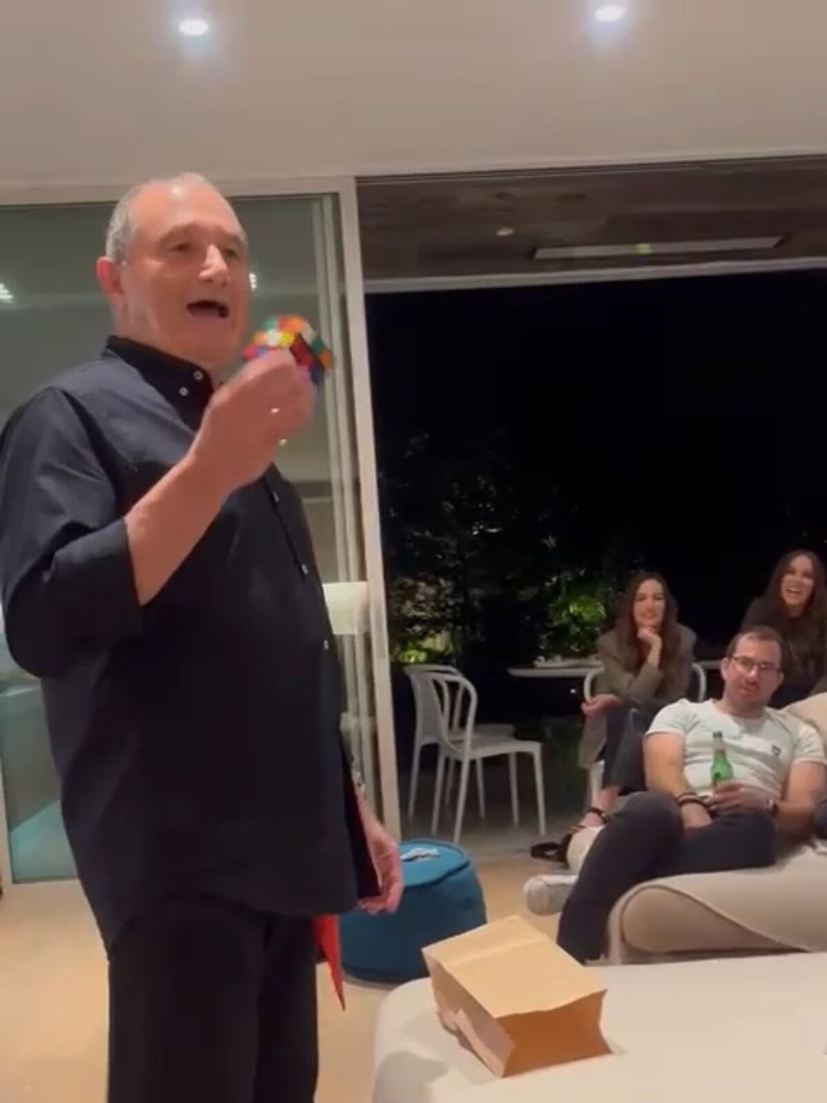 Barry performs a close-up magic routine with a colourful cube for party guests.